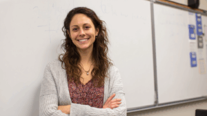 A teacher standing beside a whiteboard