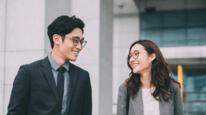 an asian man and woman young adult professionals talking to each other