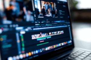 close-up of a laptop with video editing software open, showing an editing timeline with basic clips and effects.