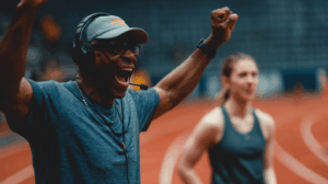A coach cheering on their athlete, who is practicing intensely.