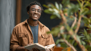 A confident young adult English learner smiling while closing a grammar book