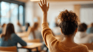 A person in a classroom, raising their hand with a puzzled expression while trying to answer a question. 