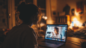 A person watching a video of native speakers discussing their future plans