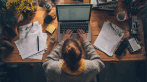 A person working at a desk with papers and a laptop