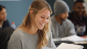 A student smiling and reviewing their notes