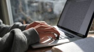 A student typing an essay on a laptop