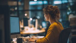 A woman at her desk, typing a response to an email 