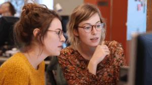 Two coworkers discussing how their project has evolved