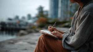 a person reflecting on their past experiences by writing on their journal