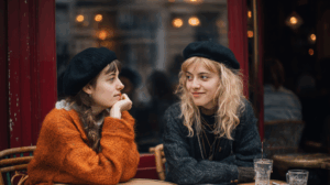 A traveler sitting in a café, looking at a photo album of their trip to Paris