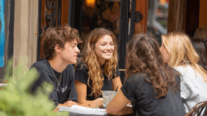 A group of friends sitting at a café, engaged in a conversation.