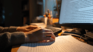 A person at a desk typing an essay