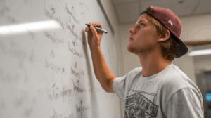 A student looking at a list of sentences on a whiteboard