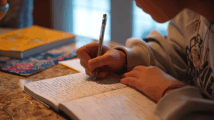 A learner showing a written paragraph to a teacher or classmate