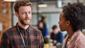 Two friends talking inside an office