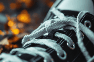 A close-up of a person’s sneaker with visibly untied and loose shoelaces