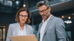 Two people in business casual looking at a laptop