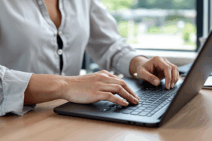 an office man or woman or young professionals typing in a laptop or checking their emails