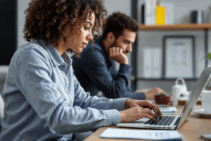 an office man or woman or young professionals typing in a laptop or checking their emails